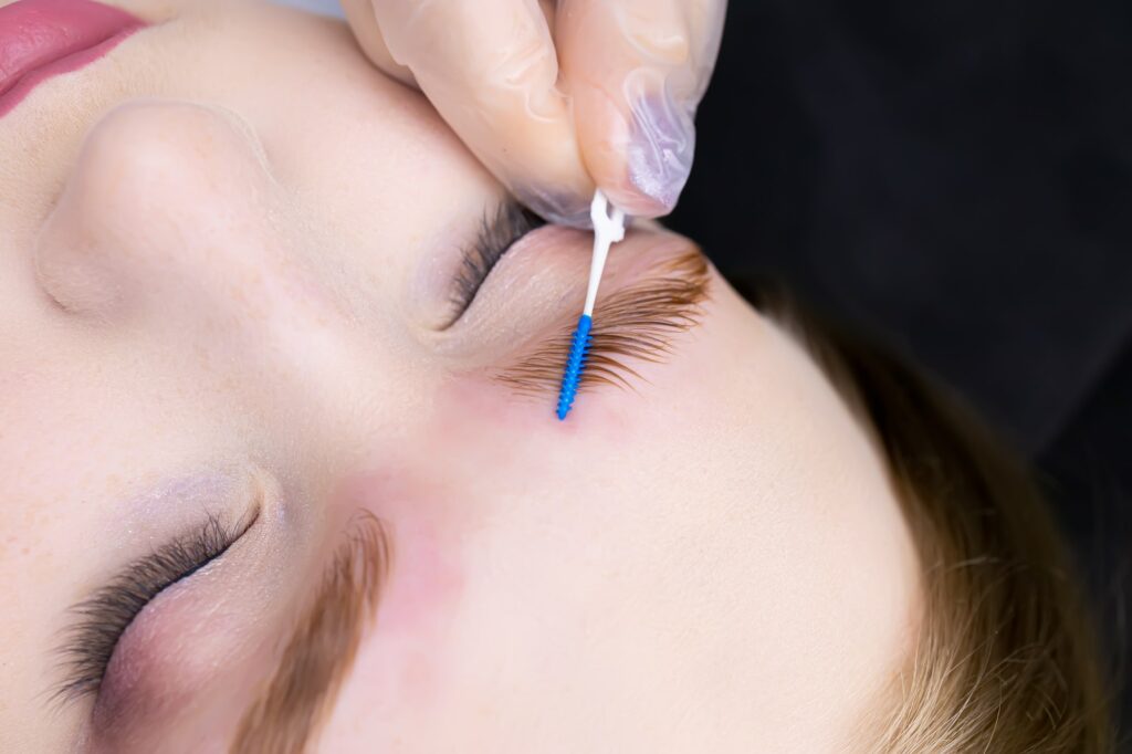 close-up of the eyebrows the master gives shape with a brush after the procedure long-term styling