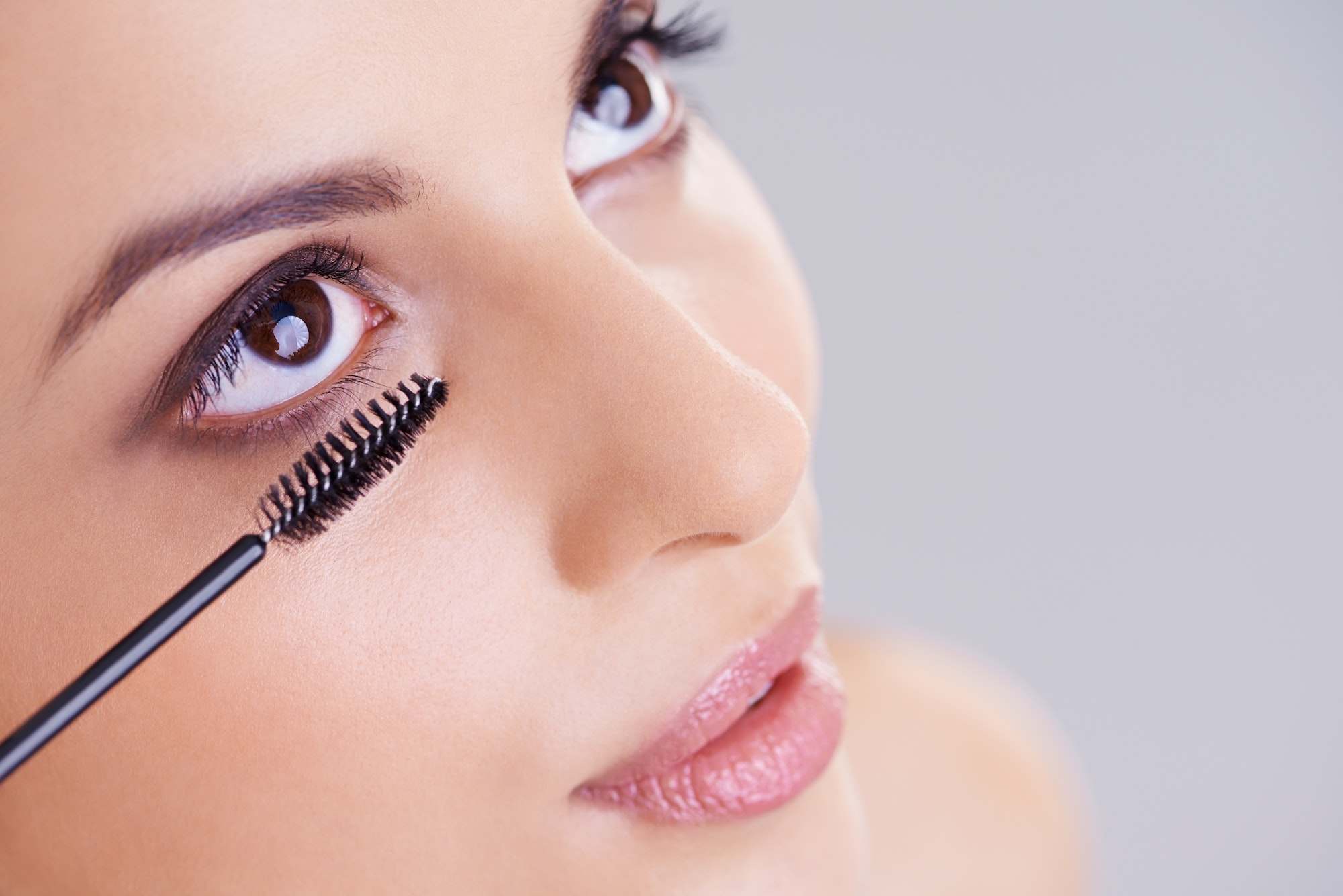 For longer, thicker lashes. Shot of a beautiful young woman applying mascara to her lashes.