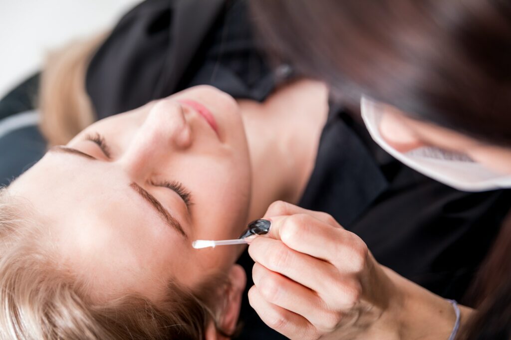 Pretty girl getting brow depilation at beauty salon