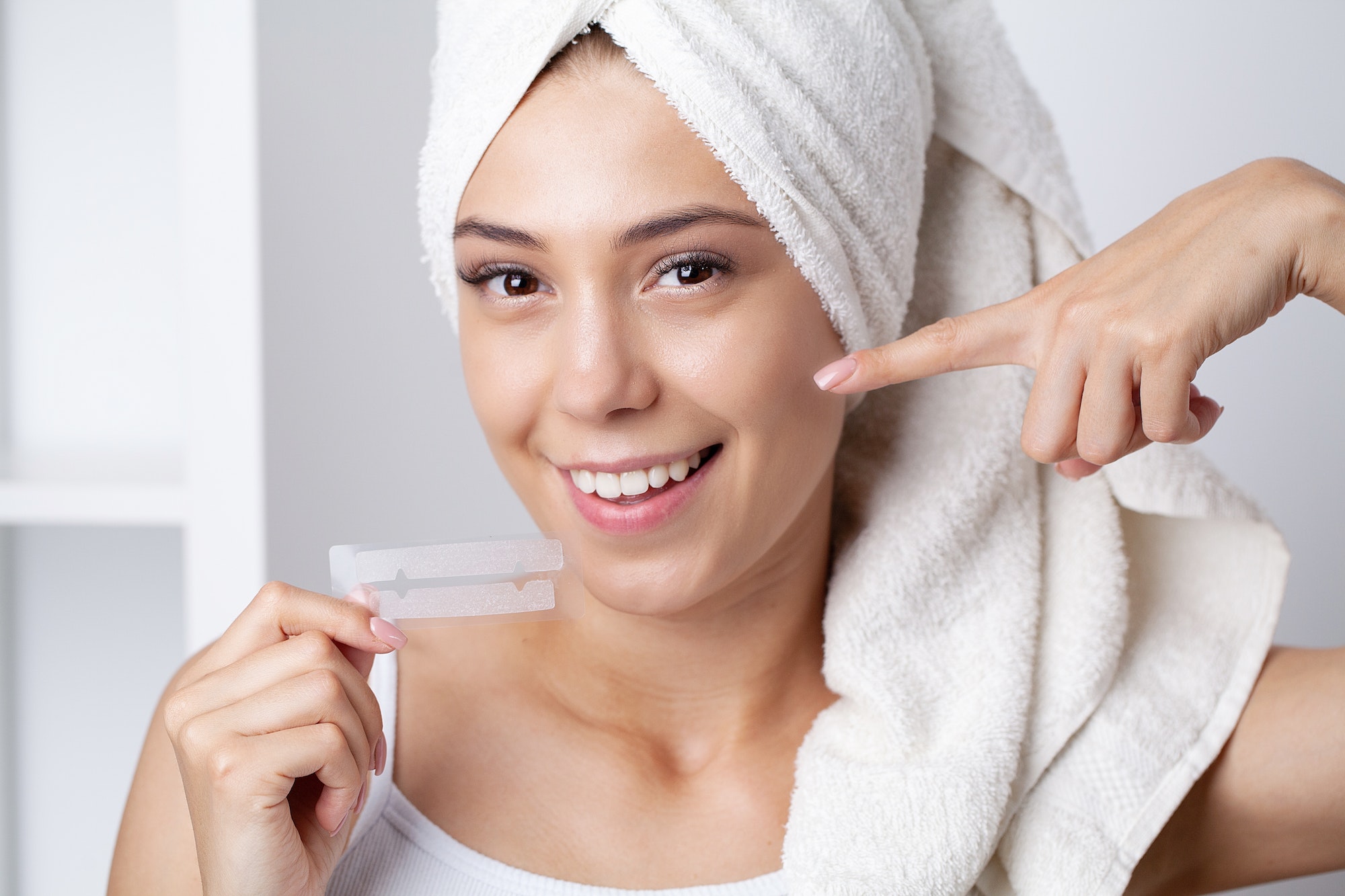 Teeth Whitening, Beautiful Smiling Woman Holding Whitening Strip.