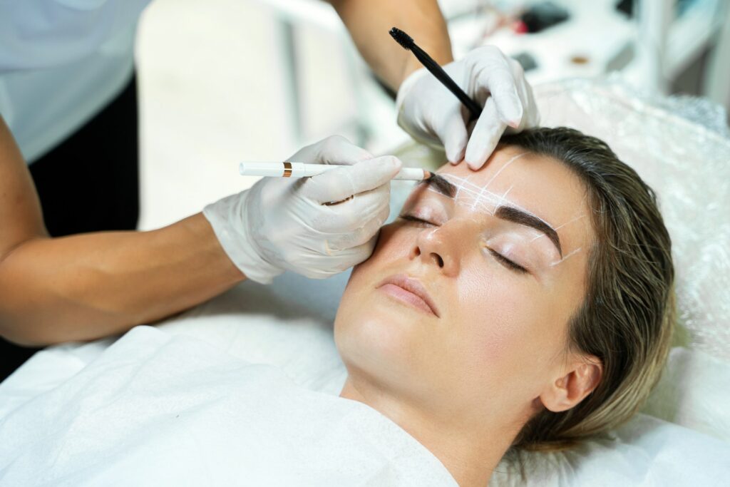 Woman during professional eyebrow mapping procedure